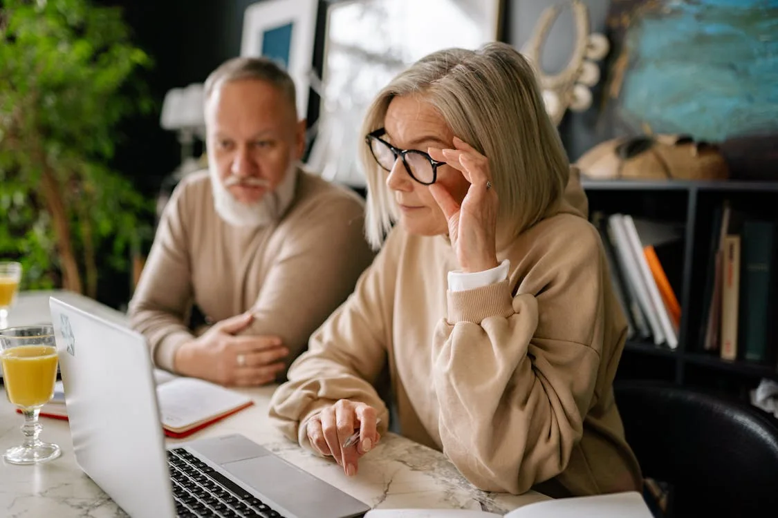 A retired couple reviewing financial planning information on a laptop.