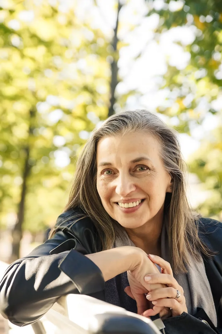 A smiling older woman sitting outdoors