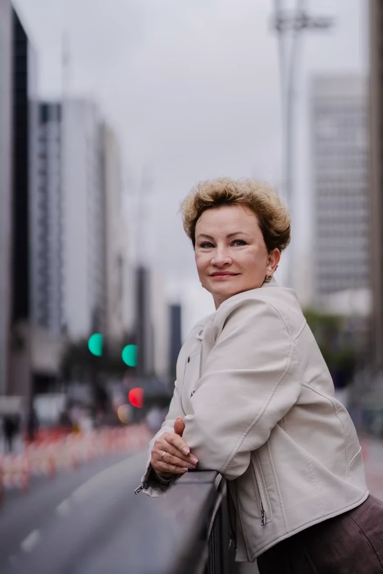 Smiling woman standing leaning against city railing