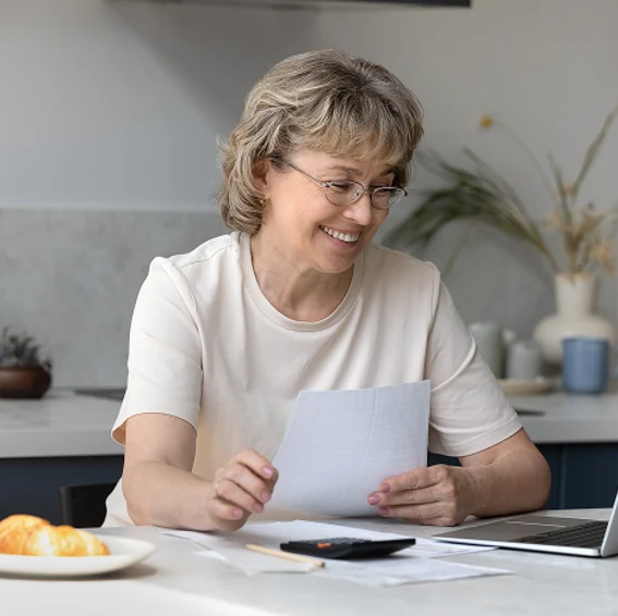 Older woman reviewing financial documents at a table