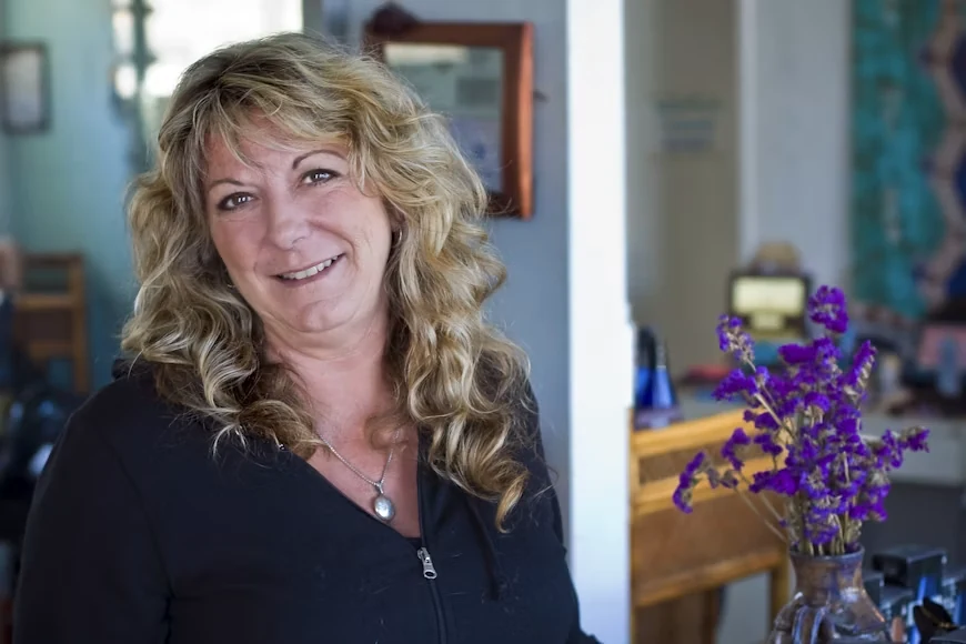 A middle-aged woman in a black shirt smiling