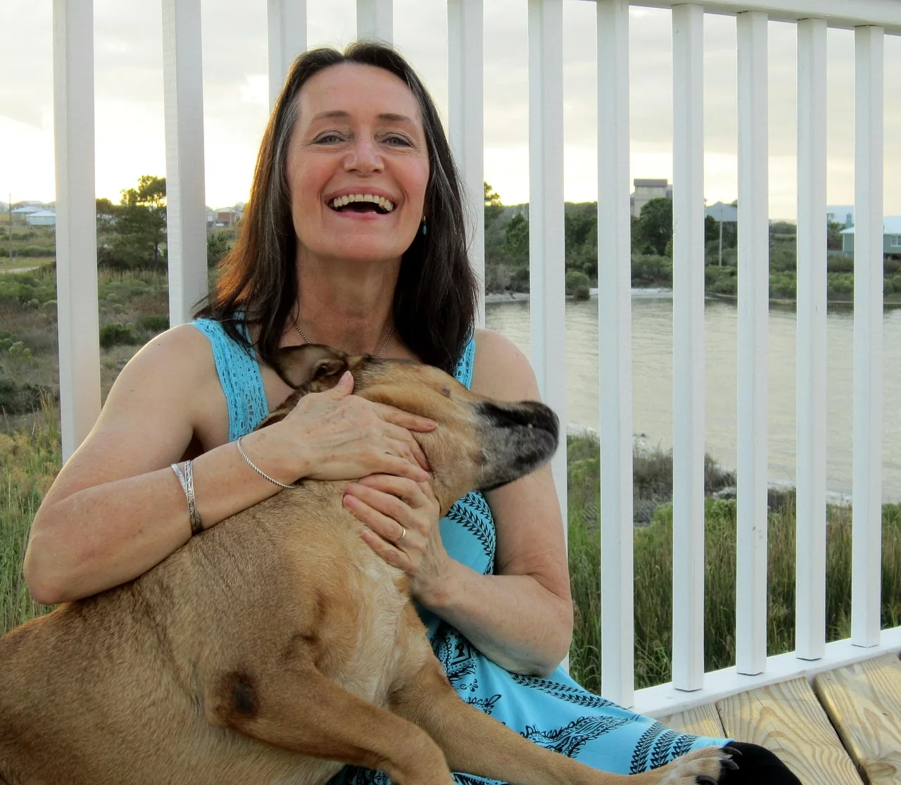 An older woman sitting outdoors with her dog.